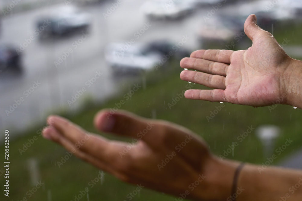 man's hands under rain
