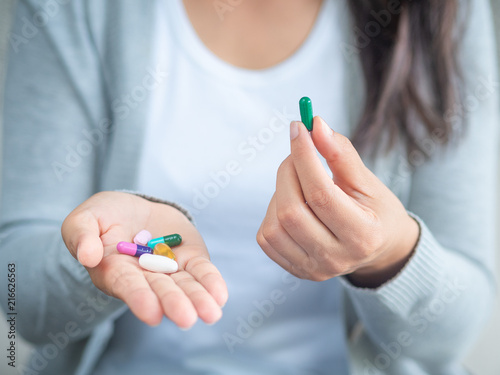 Woman hand with pills medicine tablets and capsule in her hands. Healthcare, medical supplements concept