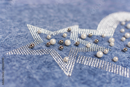 Rhinestones, pearls, beads are sewn on jeans clothes. Glamorous women's fashion.