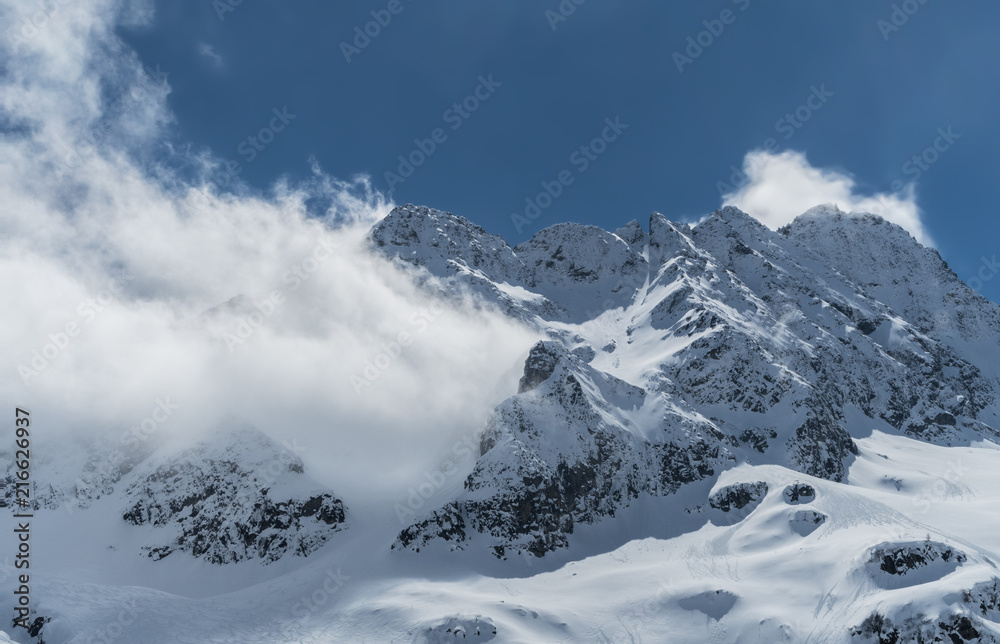 Obraz premium Peak in the italian alps covered by clouds.