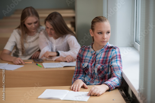 student girls are sitting at a Desk