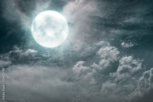 Dramatic view of full moon with dark clouds