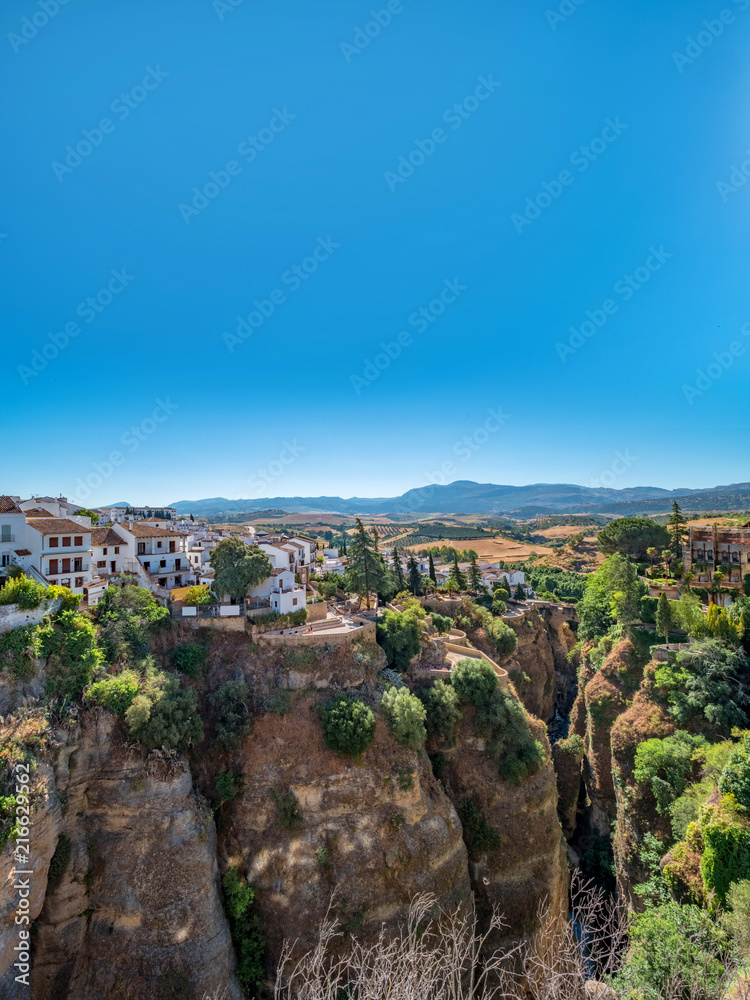 Views of the houses built on the edge of the cliff, in the ancient city of Ronda, Spain