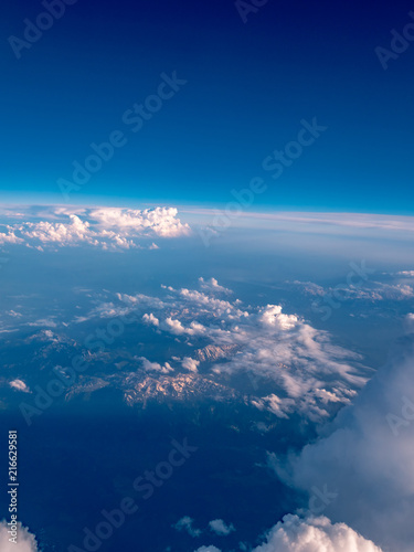 Aerial view above the clouds with mountains at sunset