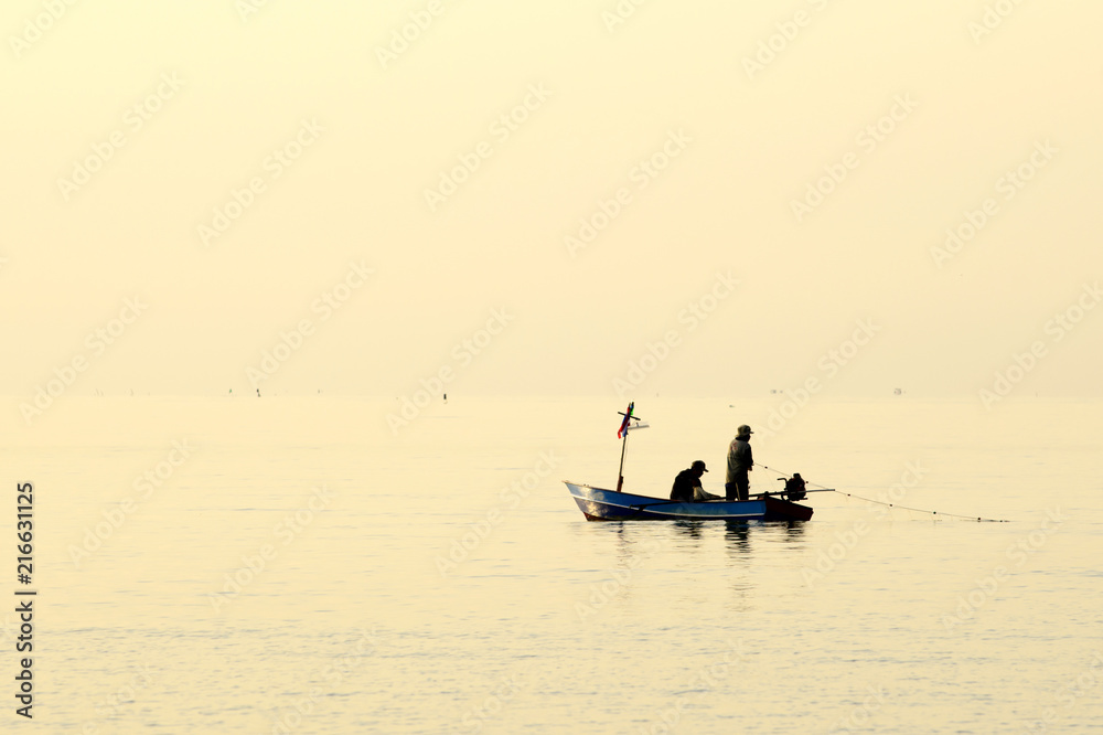Fishermen out fishing at sunrise in the sea, amidst the clouds and the sky is beautiful