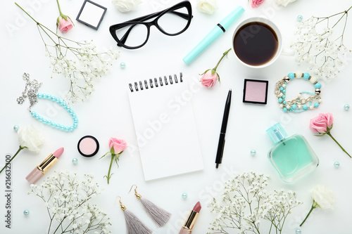 Flowers with cup of coffee and makeup cosmetics on white background