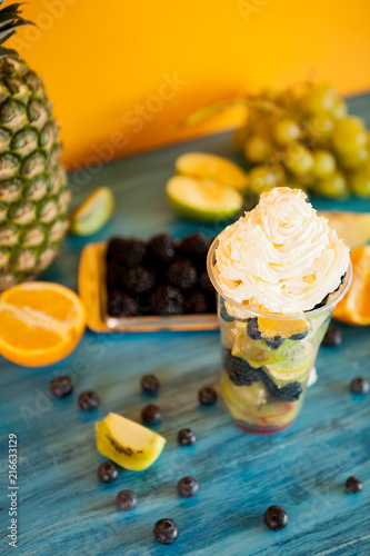 Fotografie Cup full of tasty fruits with wipped cream on top, Juicy fruits on top fop vinta