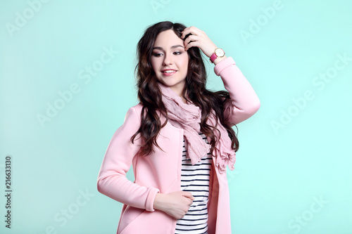 Beautiful woman in fashion clothes on mint background