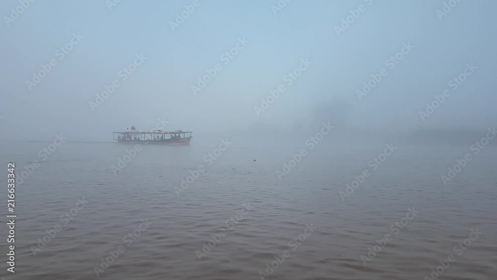 Early morning on the river Tsiribihina, Menabe region, sunrise mist and motor boat floating with sound Early morning on the river Tsiribihina, Menabe region, sunrise mist and motor boat floating with sound