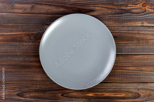Top view gray Empty round plate on wooden background