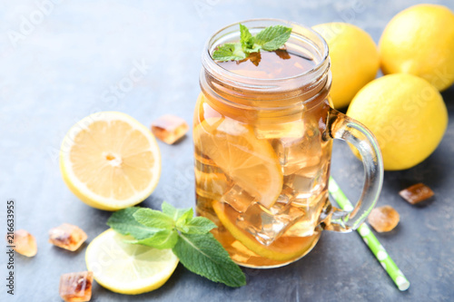 Ice tea in glass jar with lemon and mint leafs on wooden table