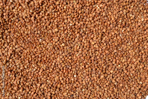 Uncooked Buckwheat laid out on a table is used as a background or decoration element.