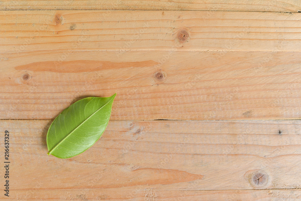 Agarwood leaves on wooden texture with text space.
