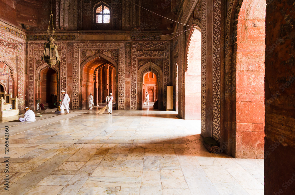 AGRA, INDIA - 5 MAY 2015: Mosque workers sweeping the marble floor of the main prayer hall in the Taj Mahal masjid, Agra, India.