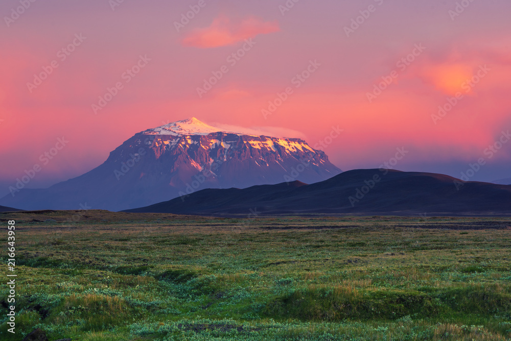 Beautiful volcanic mountain in Iceland covered with snow in pink sunset light