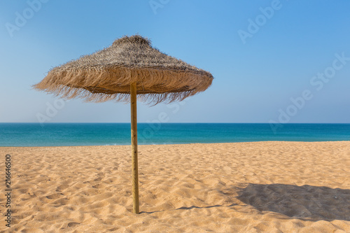 One wicker beach parasol at blue sea