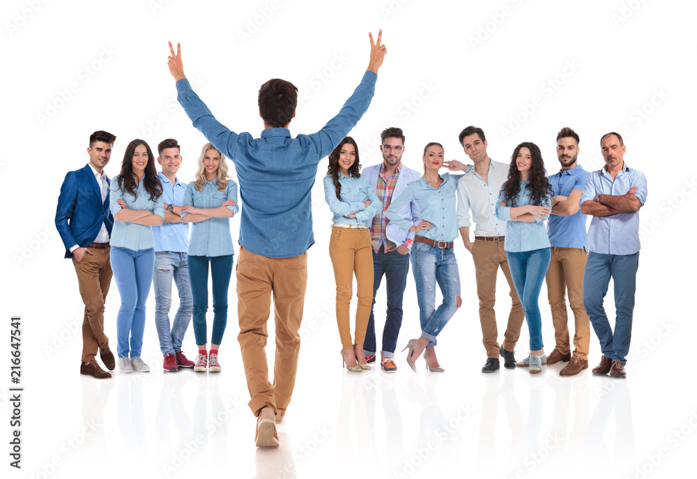 young casual man congratulates his colleagues with hands up