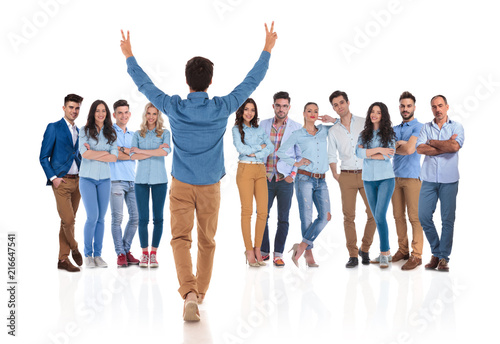 young casual man congratulates his colleagues with hands up