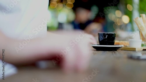 Casual man drinking espresso coffee in cafe with beautiful light bokeh background