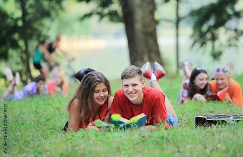 pairs of students preparing for the exam, lying on the grass in the Park