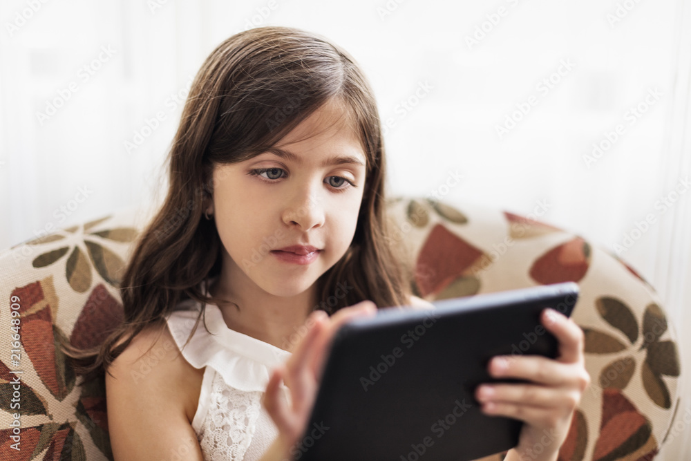 Girl using digital tablet on sofa Girl using digital tablet on sofa