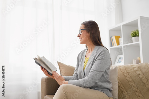Fotografia literature, education and people concept - young woman in glasses reading book a