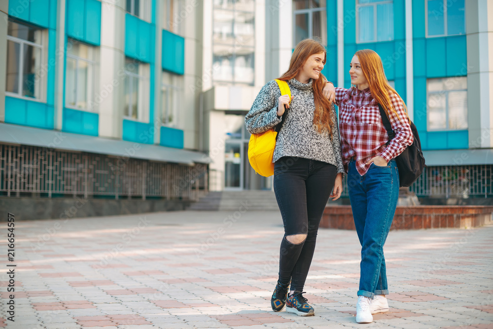 Two student female friends walking from university