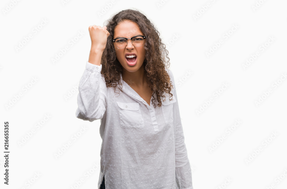 Beautiful young hispanic woman angry and mad raising fist frustrated and furious while shouting with anger. Rage and aggressive concept. Beautiful young hispanic woman angry and mad raising fist frustrated and furious while shouting with anger. Rage and aggressive concept.