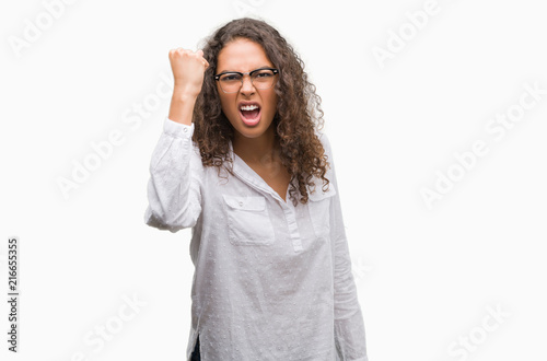Beautiful young hispanic woman angry and mad raising fist frustrated and furious while shouting with anger. Rage and aggressive concept. © Krakenimages.com