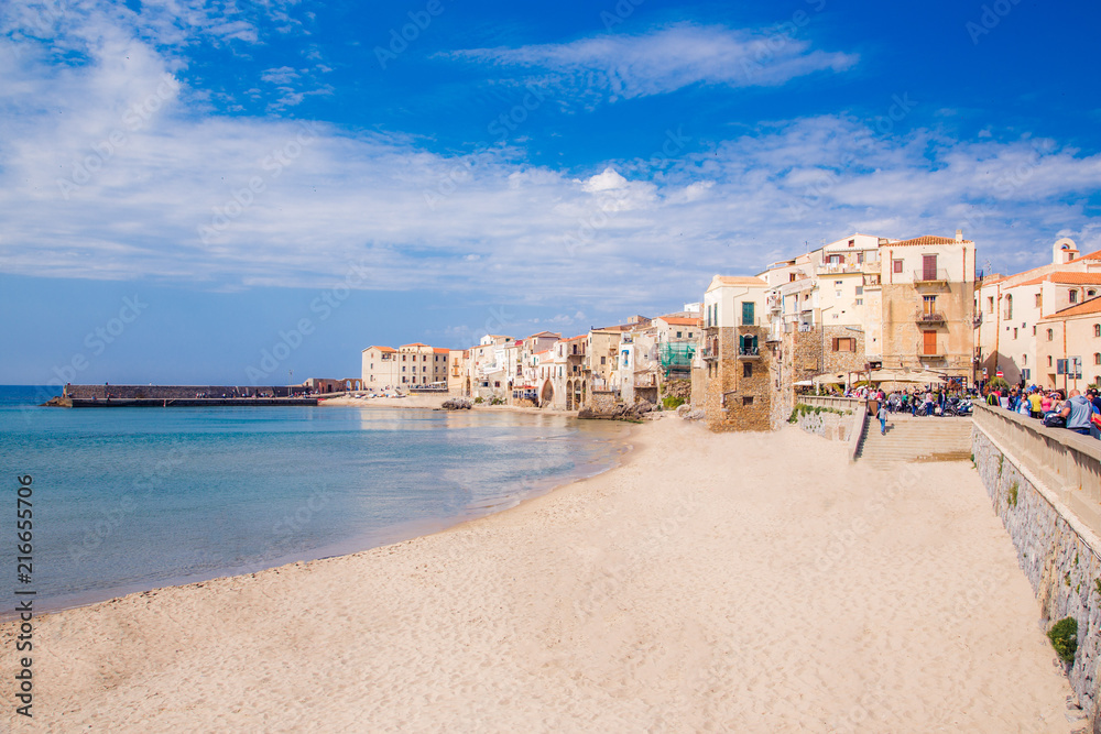 The sunny view of sandy beach of old Sicilian city Cefalu