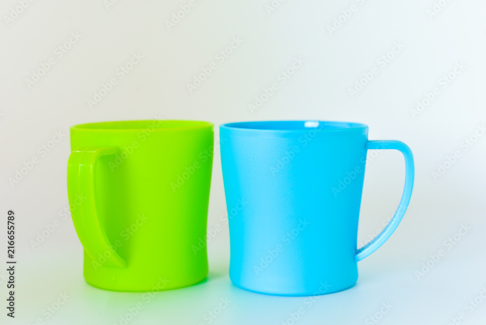 blue and green plastic mug isolated on white background. selective focus. blue and green plastic mug isolated on white background. selective focus.