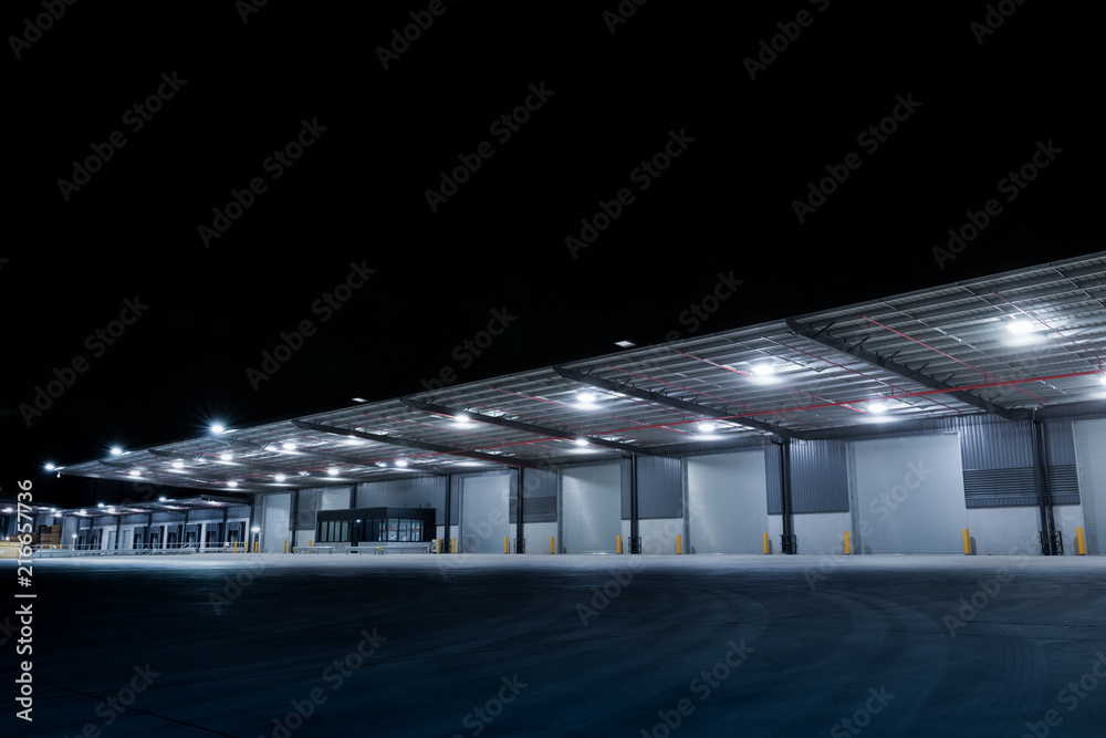 Illuminated exterior of a factory, industrial style building. Night time.