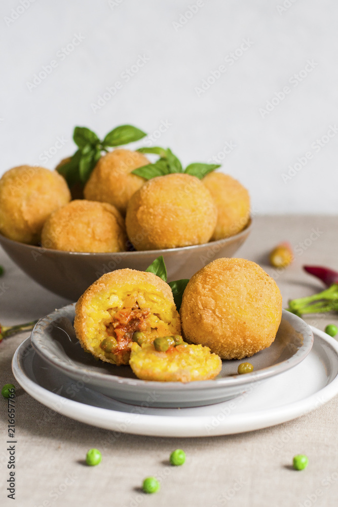 Arancini - italian rice balls which are coated with bread crumbs and then deep fried, filled with ragù (meat and tomato sauce) and peas.