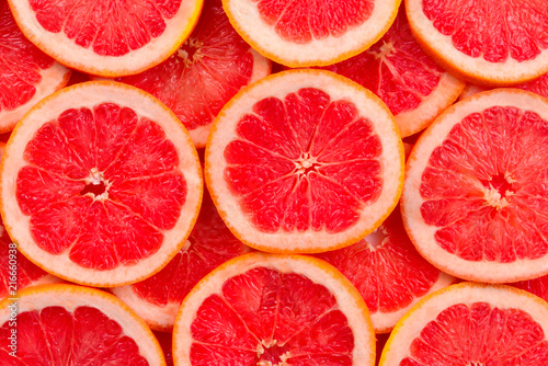 Grapefruit red juicy slices background. top view