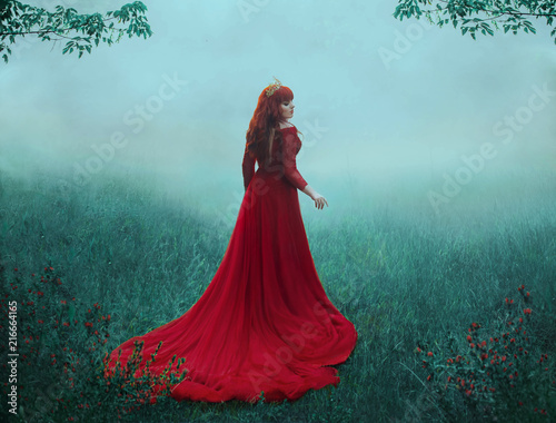 The Queen in a luxurious, expensive, red dress, walks in a thick fog with a long train. A young-haired girl in a golden crown examines her possessions. The background is cold, misty autumn. Art photo.