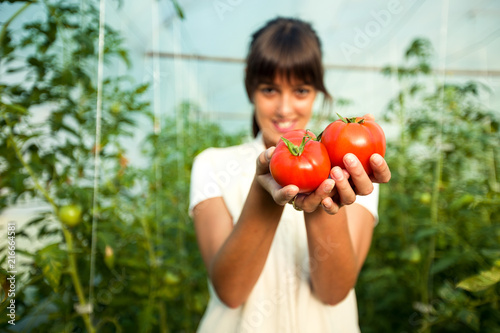 Female farmer holding fresh organic tomatoes