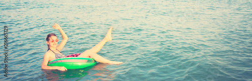 Beautiful Girl in inflatable ring having fun in the sea