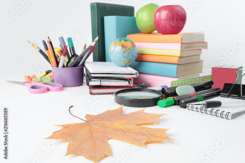 foreground is the maple leaf on the background of school supplies .photo with copy space