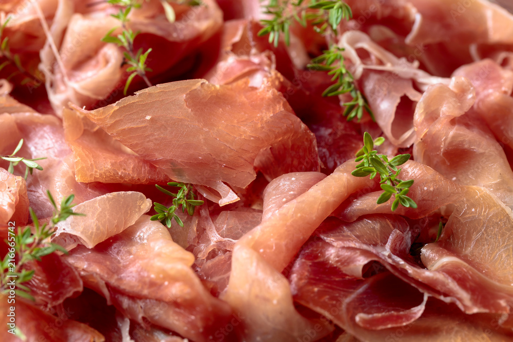 Italian prosciutto crudo or jamon with thyme . Italian prosciutto crudo or jamon with thyme .