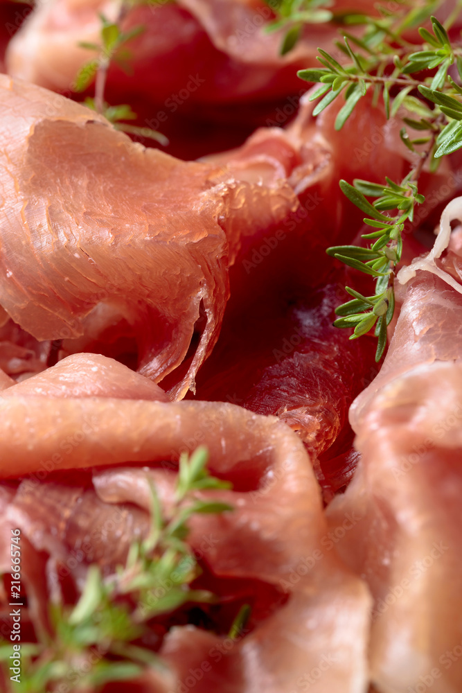 Italian prosciutto crudo or jamon with thyme . Italian prosciutto crudo or jamon with thyme .