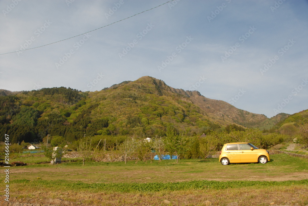山並みと黄色い車