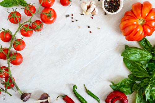 Cherry tomato branch, garlic, fresh basil, pepper on a light background. Ingredients for making sauces. Italian Cuisine. Free space for your project.