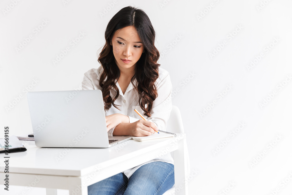 Confident young asian businesswoman taking notes