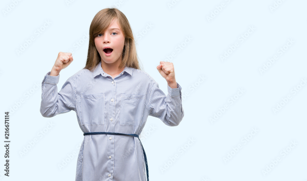 Young blonde toddler wearing blue shirt screaming proud and celebrating victory and success very excited, cheering emotion Young blonde toddler wearing blue shirt screaming proud and celebrating victory and success very excited, cheering emotion
