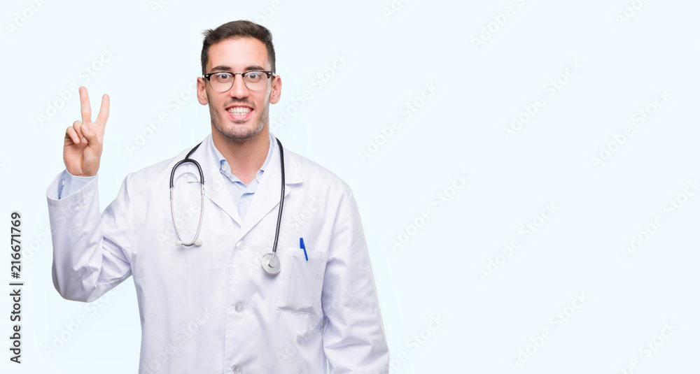 Handsome young doctor man showing and pointing up with fingers number two while smiling confident and happy. Handsome young doctor man showing and pointing up with fingers number two while smiling confident and happy.
