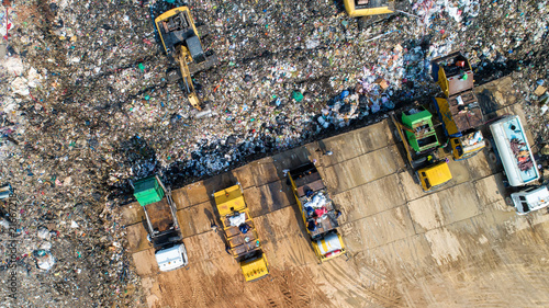 A lot of waste is disposed of in the waste disposal pits. Loaders is working on a mountain garbage. Aerial view and top view.
