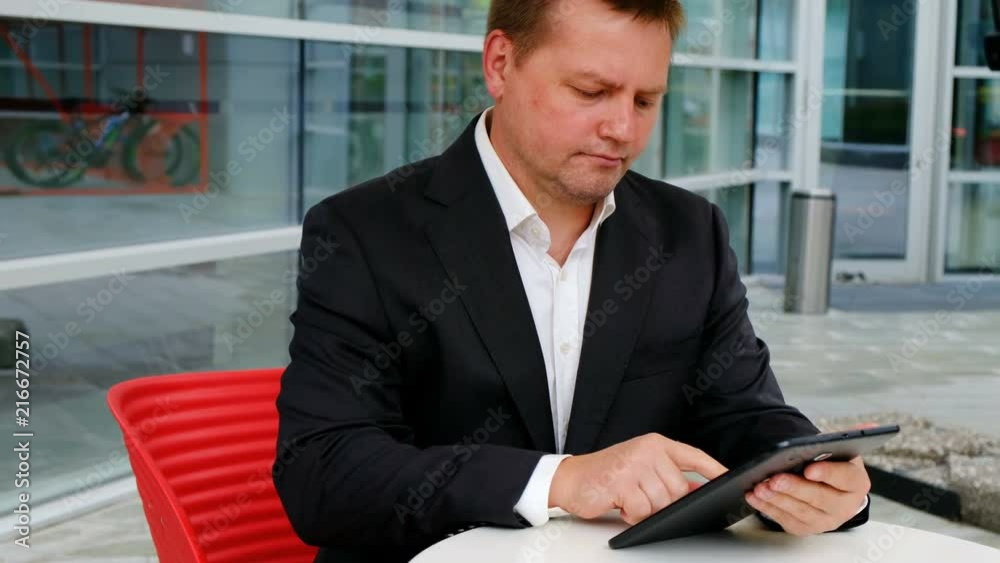 Young confident businessman holding tablet, outside Young confident businessman holding tablet, outside