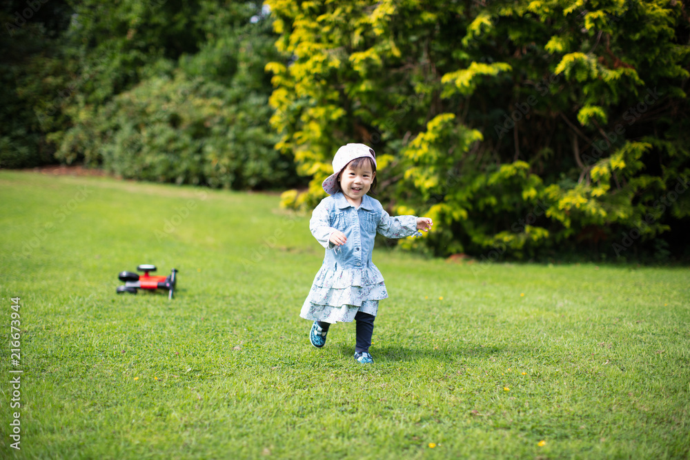 baby girl play bike in Summer forest park baby girl play bike in Summer forest park