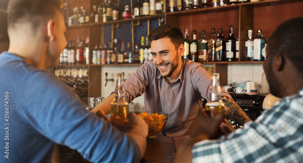Men drinking beer and communicating with bartender