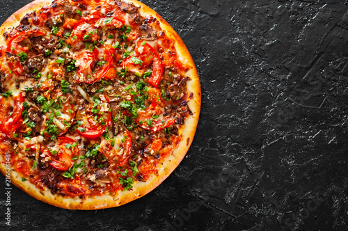 Pizza with Mozzarella cheese, mushrooms, Tomatoes, pepper, Spices and Fresh Basil. Italian pizza. on black background. with copy space. top view